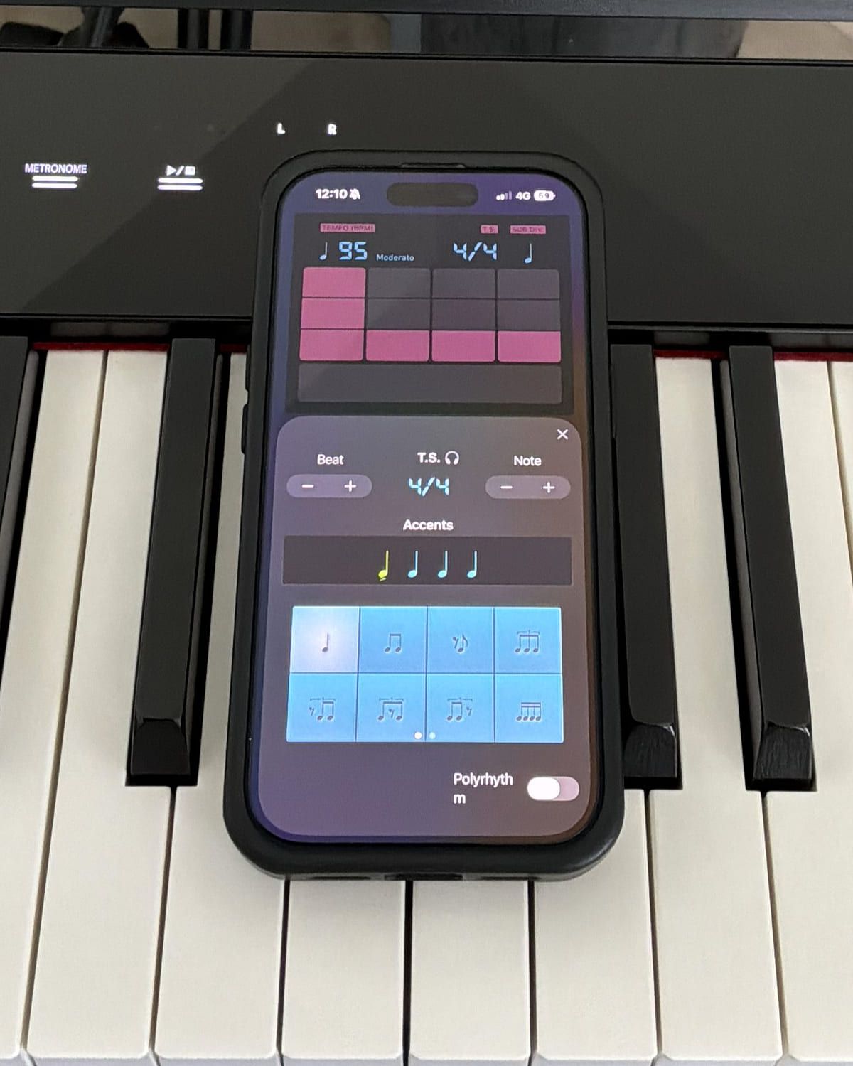The Pro Metronome settings panel open on the same phone, showing the four-beat accent row, a grid of eight note-value subdivisions and a polyrhythm toggle.