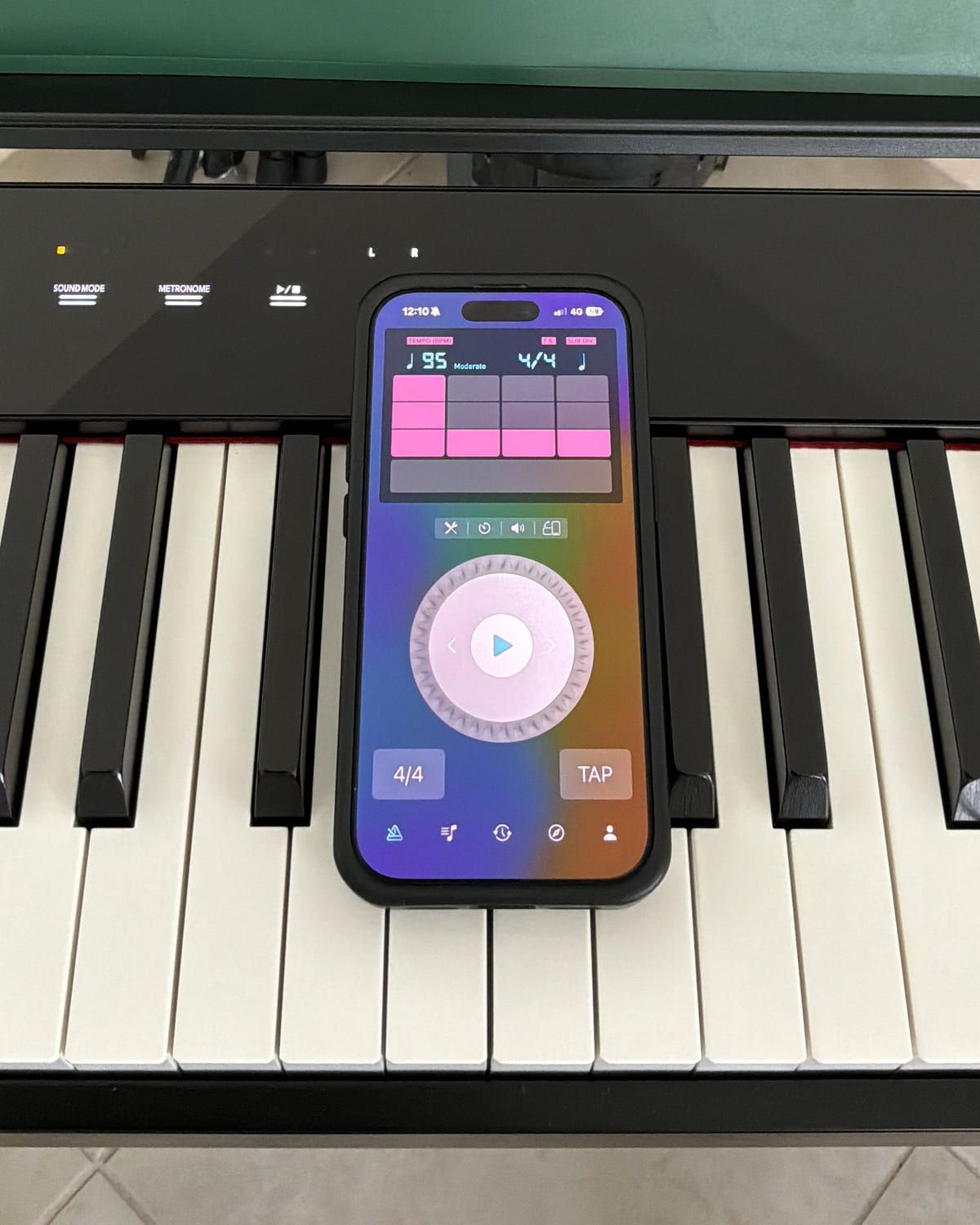 Pro Metronome running on an iPhone resting on the keys of a digital piano, showing 95 bpm in 4/4 with a three-row accent grid above the tempo dial.