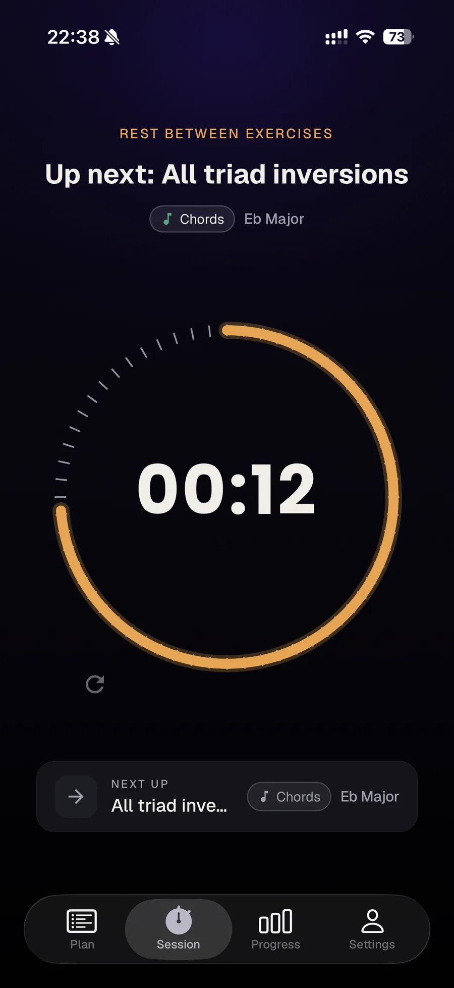 A timed rest between exercises: a circular dial with an amber arc counts down 12 seconds, labelled 'Rest between exercises', with 'Up next: All triad inversions' shown below.